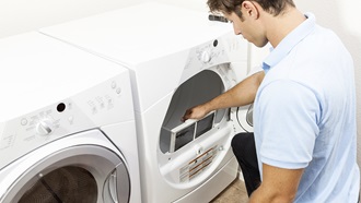 Un homme qui change le filtre de sa machine a laver